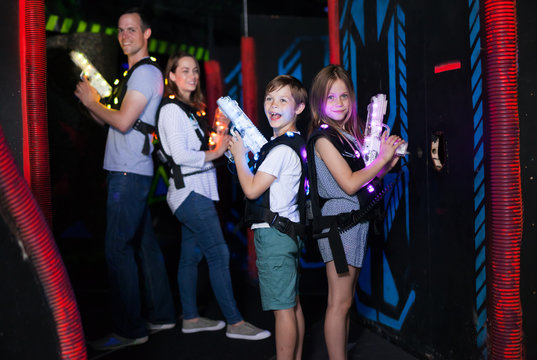 Kids standing back to back with laser pistols