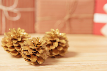 golden pine cones glittered christmas and gift box decoration on wood table background. copy space.