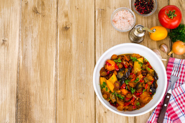 Ragout of vegetables in bowl on wooden table