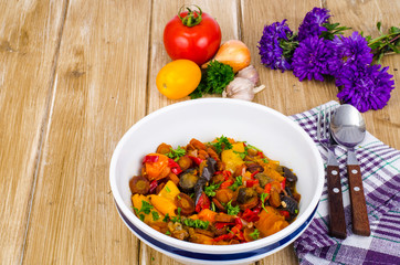 Ragout of vegetables in bowl on wooden table