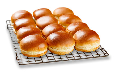 Brioch buns cooling on a wire tray.