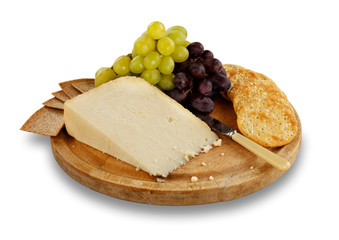 Cheese, crackers and grapes on wooden board.