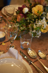 Setting a summer wedding dinner table in a rustic style.