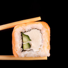 Japanese rolls on black background isolated with chopstick