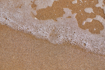 Soft wave of the sea on the sandy beach as background