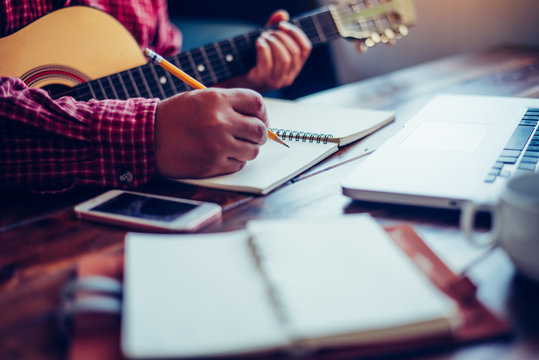 Composers are writing songs on the table with guitars.