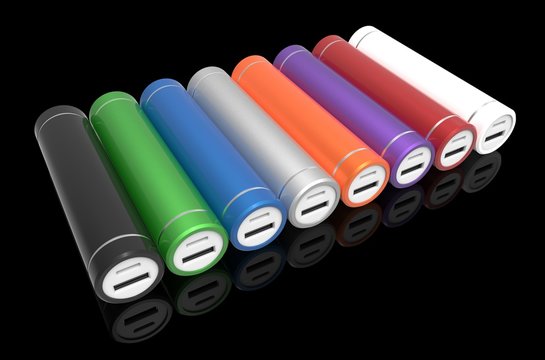 Eight colorful cylindric power banks isolated on black background. Black, green, blue, silver, orange, violet, red, white. 3D rendering