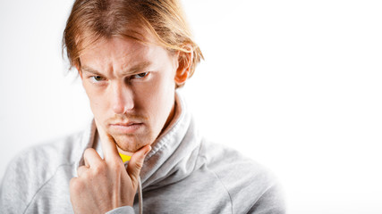 Male portrait of a fair-haired man of European appearance, on a white background. Emotions. Serious face