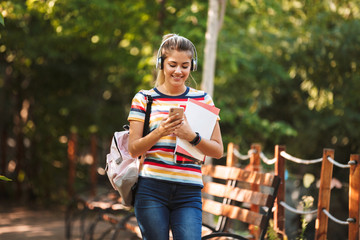 Happy young teenage girl carrying backpack