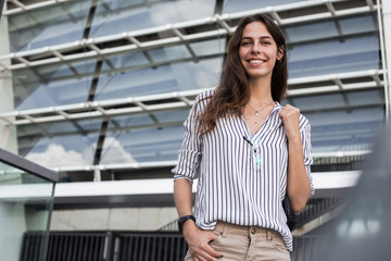 Business woman near office. Portrait of beautiful smiling female in fashion clothes while standing outdoors. Waiting for unofficial meeting. High Quality. Young professional injeneere. Architect