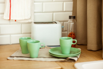 Fototapeta na wymiar toaster with cups on the kitchen light