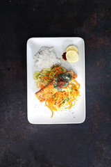 Ryba z grilla w sosie śmietanowo szpinakowym na warzywnym spaghetti  z marchewki i cukinii. - obrazy, fototapety, plakaty