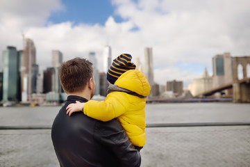 Father and his little son looking at the skyscrapers of Manhattan and Brooklyn bridge