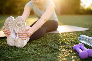 Mature woman practicing yoga outdoor exercise or doing fitness