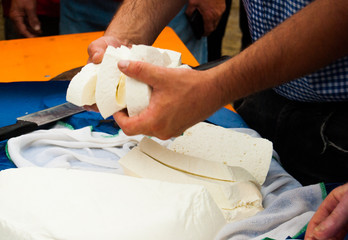 Man cutting freshly made cheese