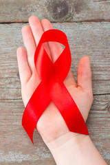 Aids red ribbon on woman's hand support for World aids day and national HIV/AIDS and aging...