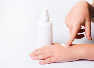 Children's hands and cream in a white tube. On white background. Baby skin care.