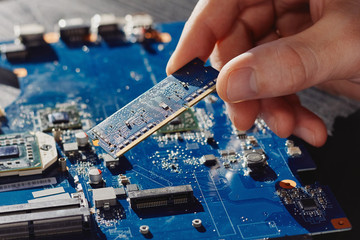 Technician plugs in memory to computer motherboard