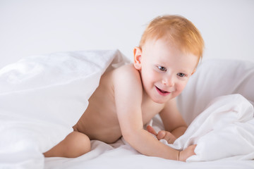 Habby young smilling child boy in white bed