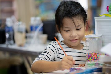 Asian girls are coloring happily in school