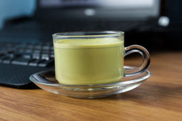 Cup of hot green tea on the table.
