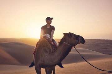 Camel riding in desert