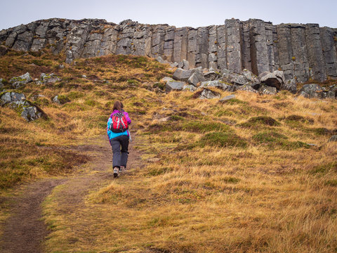 Tourist girl walking near Gerduberg basalt columns, Iceland