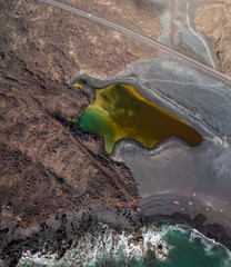 Vista aerea del piccolo lago sotto la montagna Bermeja, vista della spiaggia nera e della strada...