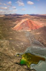 Vista aerea della montagna Bermeja di un color rosso intenso, circondata da campi di lava. Strada...