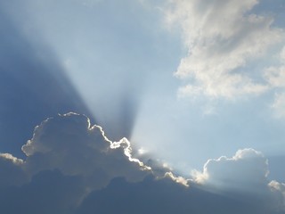Bright sky with the sun ray behind the cloud.  Scenic clouds and sky, beautiful sky and sunlight behind clouds.  Full frame shot of sky with the sun ray behind the cloud.  Wonderful sky and sunray.