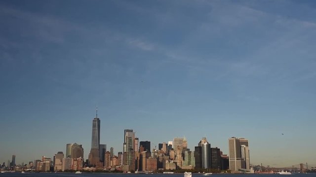 Skyline with famous skyscrapers of Manhattan and East River at sunset. Water tour to the island of Liberty.