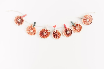 Christmas composition. Garland made of dried orange, lemon on white background. Christmas, New Year, winter concept. Flat lay, top view, copy space 