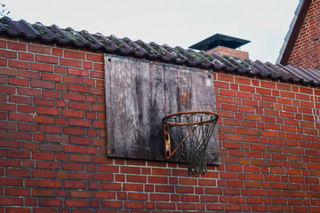 alter Basketball korb an Backsteinwand und bewölktem Himmel 
