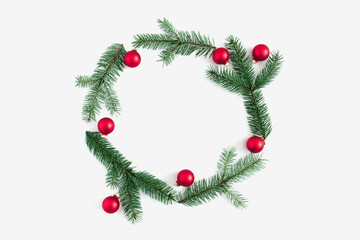 Christmas composition. Wreath made of green fir tree branches and red balls on white background. Christmas, New Year, winter concept. Flat lay, top view, copy space 