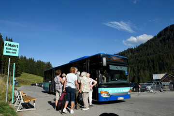 an der auenhütte im kleinwalsertal warten wanderer auf den bus