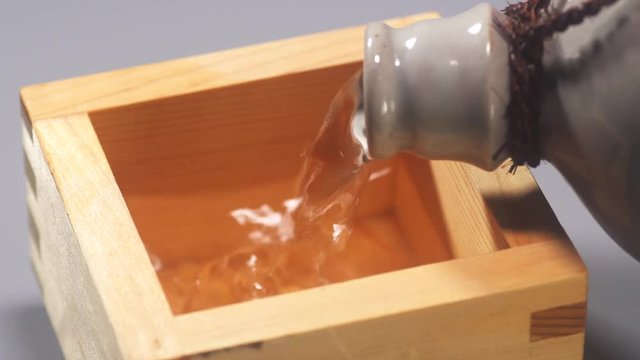 Sake served in a Japanese square wooden measure cup,