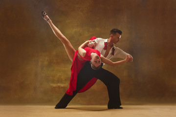 Flexible young modern couple dancing tango in studio. Fashion portrait of attractive dancing couple. Man and woman. Passion. Love. perfect skin facial and make-up. Human emotions - love and passion - obrazy, fototapety, plakaty