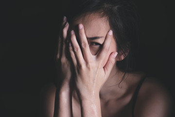 Sad depressed woman suffering from family life. women sitting in dark room cryng, palm close her face. Young beautiful women thinking how to solve problem.