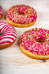 Pink donuts on a wooden background.