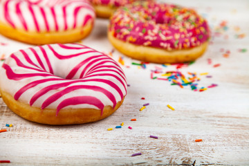 Pink donuts on a wooden background.