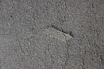 Asphalt surface texture detail with fractures cracks dent close up