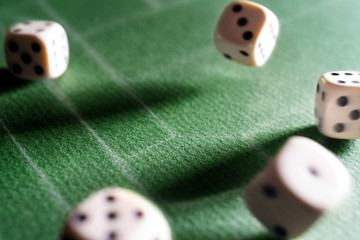 Dice game. Dice on the table. Illuminated with a contrasting light. Long shadows on the diagonal.