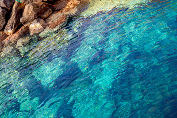 Blue clear water and rocks of island Santorini, Greece