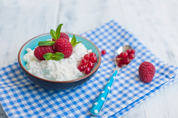 Breakfast with raspberry berries and porridge. Healthy morning meal on the table near the window.