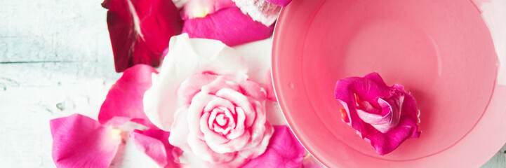 Banner Bowl of aroma spa water with rose petals on towel, closeup