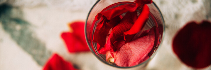 Banner glass delicious refreshing drink of rose petal flower on blue wooden background, infusioned water