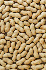 Peanuts in their shell textured food background.