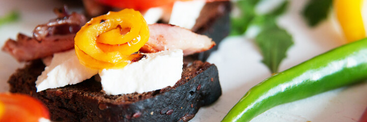 Selection of tasty Bruschetta: tomato and pepper grill, soft cheese, meat, Italian herbs, whole wheat bread.