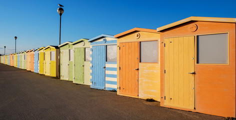 Naklejka premium A row of twenty colorful beach huts with a diminishing perspective on a promenade, Seaford, Sussex, UK