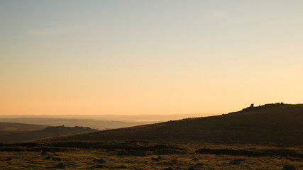 Fototapeta na wymiar Stunning sunset silhouette landscape image of Foggintor in Dartmoor